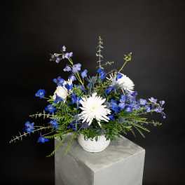 Blue and white flower arrangement in a white vase