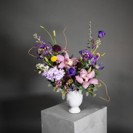 Mixed bouquet of pink and purple flowers in a white vase