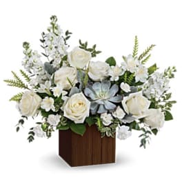 White roses and mixed white flowers in a wooden cube vase