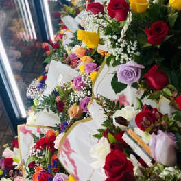 Rows of colorful rose bouquets wrapped in white paper
