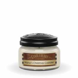 A jar candle with a black lid labeled Nana's Christmas Cobbler