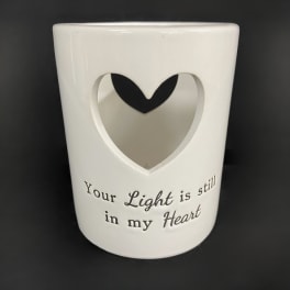White ceramic memorial candle holder with a heart cutout and printed text