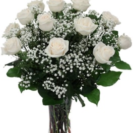 White roses and baby's breath in a clear glass vase