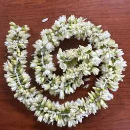 White flower garlands arranged in loops on a wooden surface