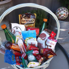 Gift basket filled with assorted snack packages and two bottles