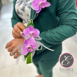 Purple orchid corsage with silver ribbon on a wrist