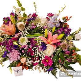 Large mixed flower arrangement with lilies, roses, and daisies