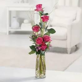 Tall pink rose arrangement in a clear glass vase