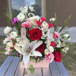 Bouquet of red and white flowers in a pink gift box