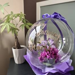 Purple birthday balloon with flowers and ribbon
