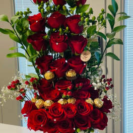 Tall arrangement of red roses in a white hatbox with gold lettering