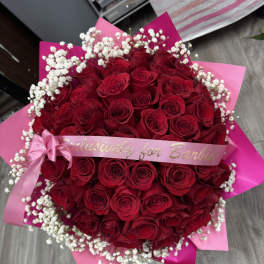 Large bouquet of red roses with white baby's breath and pink ribbon