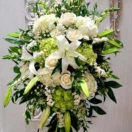 Large white and green floral standing spray with lilies and roses