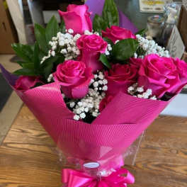 Bouquet of hot pink roses with baby's breath wrapped in pink paper