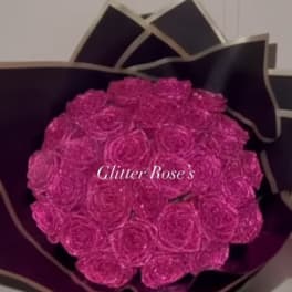 Bouquet of bright pink roses wrapped in dark paper