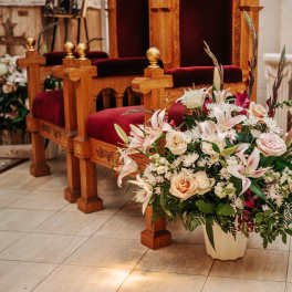 Large floral arrangement with lilies and roses in a church interior