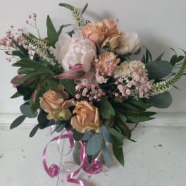 Peach and blush bouquet in a glass vase with pink ribbon