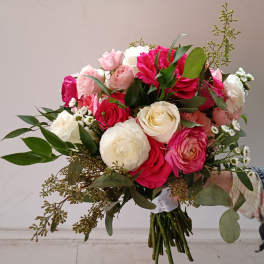 Hand-tied bouquet of pink and white roses with greenery