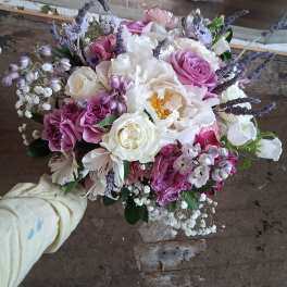 Handheld bouquet of pink and white flowers with lavender accents