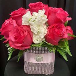Pink roses with white flowers in a decorative square vase