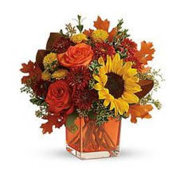 Autumn bouquet with sunflowers and roses in an orange vase
