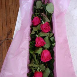 Long bouquet of hot pink roses wrapped in pink paper
