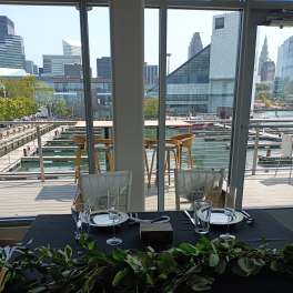 Green garland draped across a black table at a waterfront dining setup