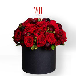 Red roses arranged in a black round box