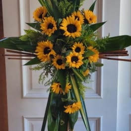 Standing sunflower spray on an easel with dark green foliage