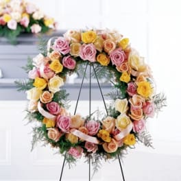 Circular wreath of pastel roses on a black stand