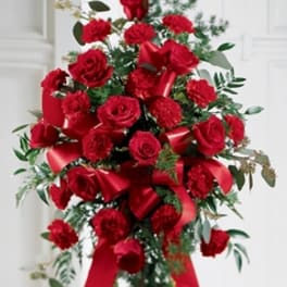 Red roses and carnations arranged on a standing easel with ribbon
