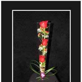 Tall glass vase with red roses and small white flowers