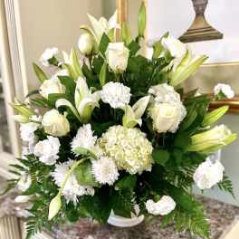 White floral arrangement with lilies, roses, hydrangea, and carnations