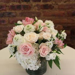 Pink and white roses with hydrangeas in a dark vase