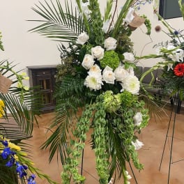 Tall white and green floral standing spray with roses and cascading greenery