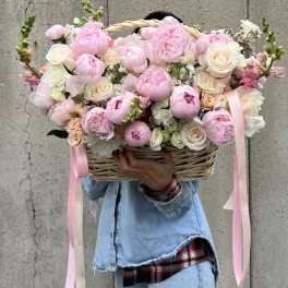 Large basket of pink and white flowers with ribbon streamers