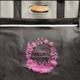 Black insulated tote bag with a pink floral shop logo