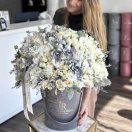 Large bouquet of white and silver flowers in a gray hatbox