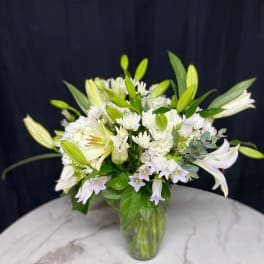 White lily bouquet in a clear glass vase