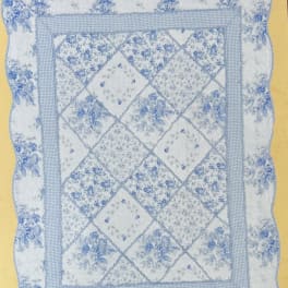 Blue and white quilted pillow with floral patchwork pattern