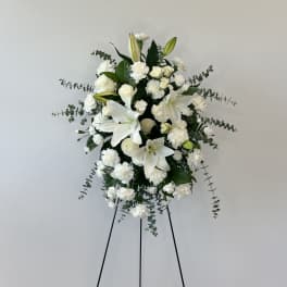 White floral standing spray on a black easel