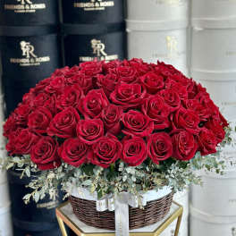 Large dome of red roses in a wicker basket with eucalyptus