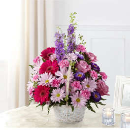 Pink and purple mixed flowers arranged in a white basket