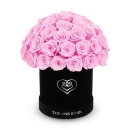 Pink roses arranged in a black round box