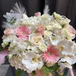 Large bouquet of white and pink flowers in a pink hatbox