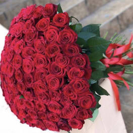 Large bouquet of red roses with green leaves and red ribbon