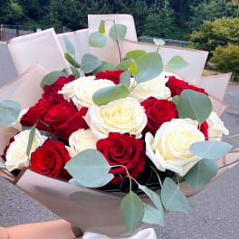 Bouquet of red and white roses with eucalyptus in beige wrap