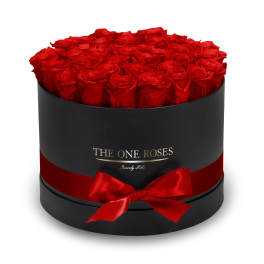 Round box filled with red roses and tied with a red ribbon