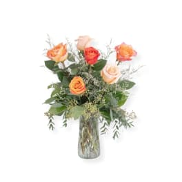 Bouquet of orange and peach roses in a clear glass vase
