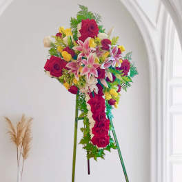 Standing floral spray of red roses, pink lilies, and yellow blooms on an easel